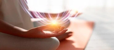 Portada del artículo. Mujer sentada haciendo meditación sobre una esterilla con los dedos índice y pulgar en contacto